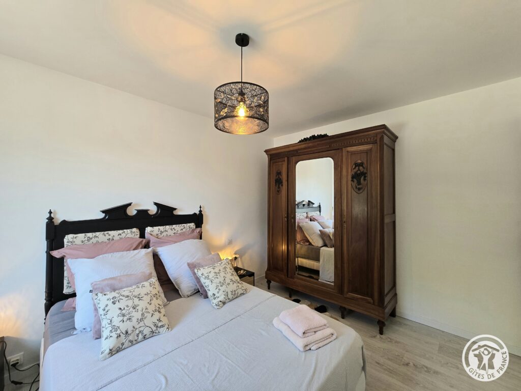 Chambre Étoffe du gîte Le Petit Lac en Périgord Pourpre avec lit double et armoire ancienne