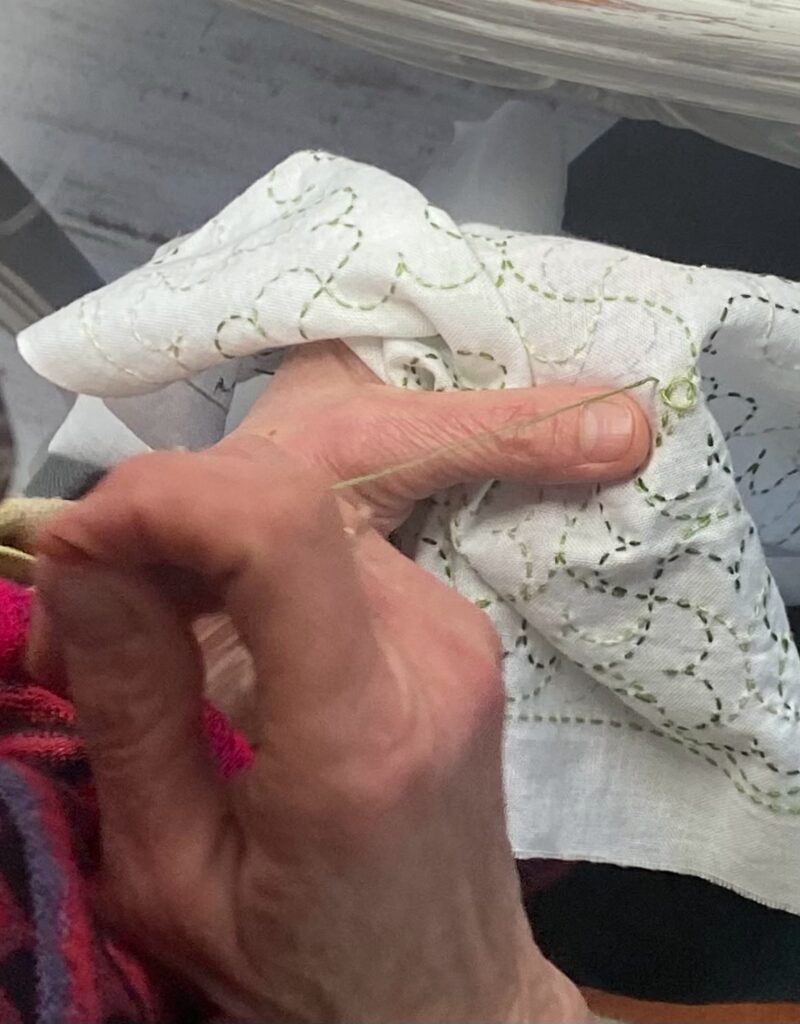 Réparation textile inspirée du sashiko sur un tissu usé.