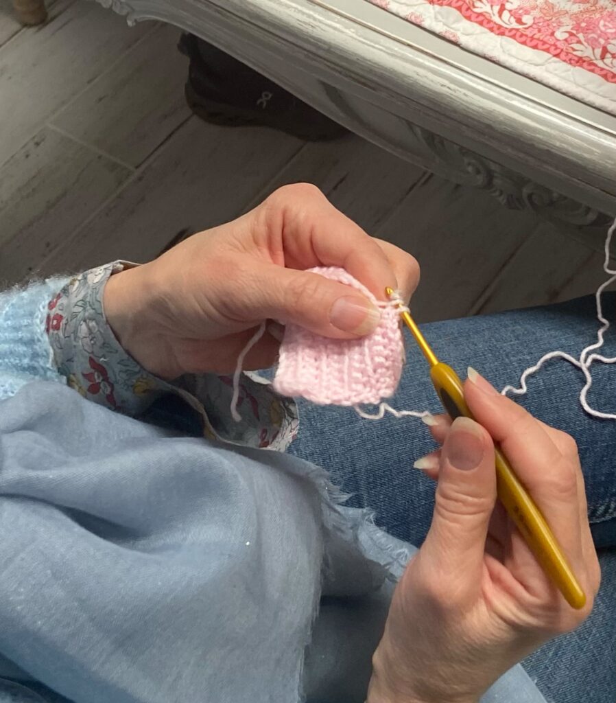 Réalisation des premières mailles au crochet avec un fil clair.