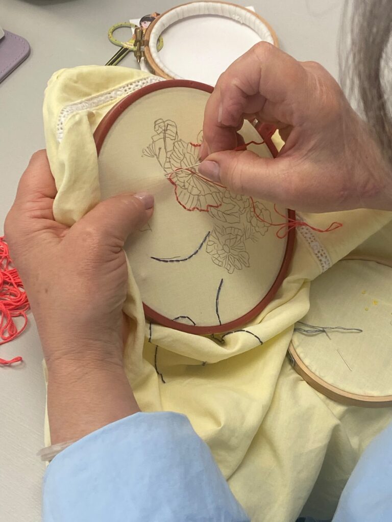Broderie à la main sur tissu tendu dans un tambour à broder.