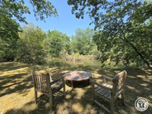 Espace repas extérieur ombragé dans le jardin du gîte Le Petit Lac